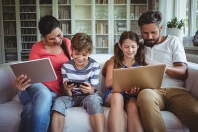 Family on couch with digital devices