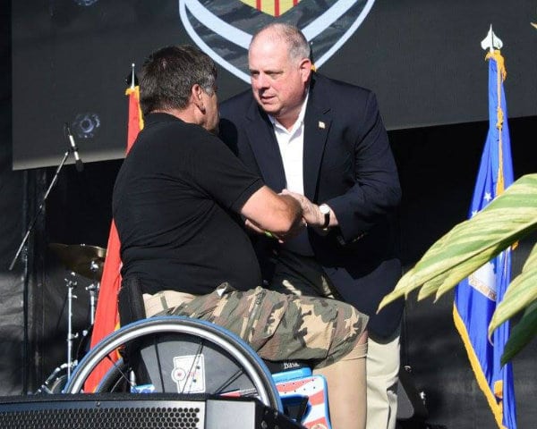 Man in wheel chair shaking hands with Governor Hogan
