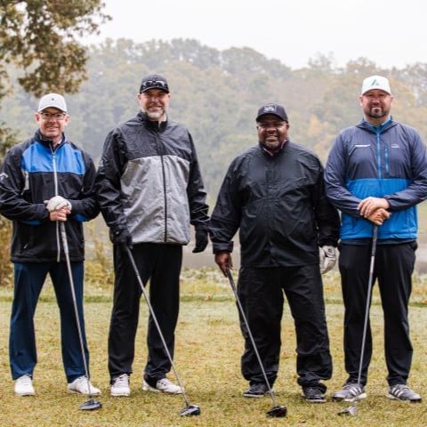 square photo with 4 golfers standing on golf course