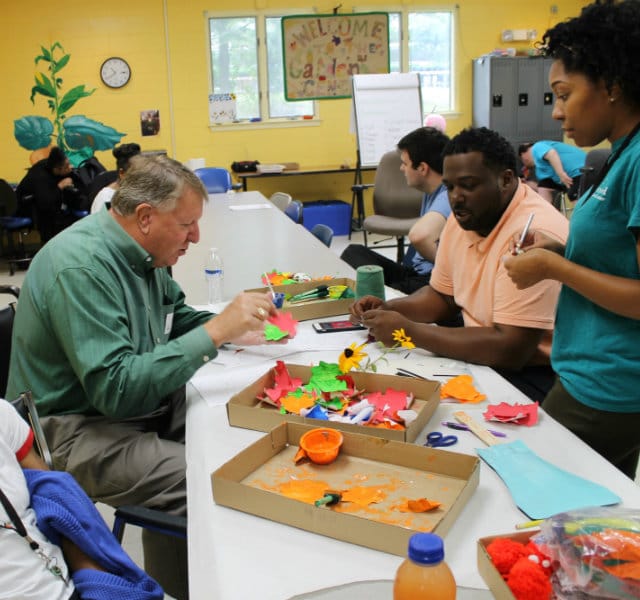 A photo of Senator Edward R. Reilly participating in arts and crafts with Melwood day services program participant.