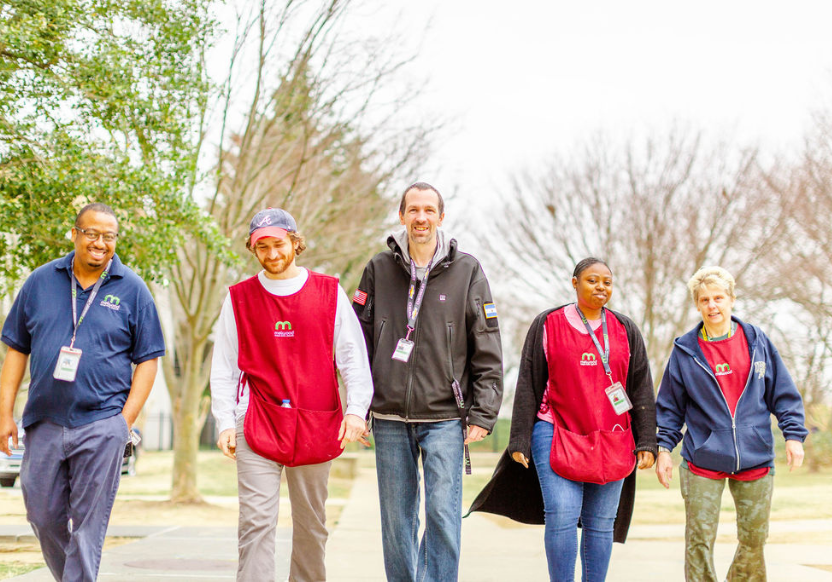 A group of five Melwood workers walking together outside