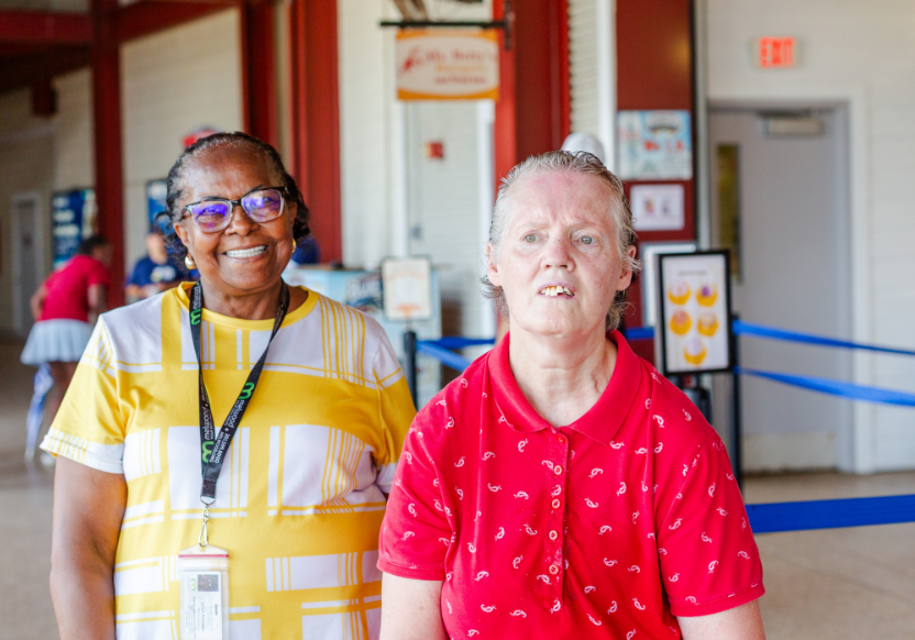 Janice Robinson, a Melwood Direct Support Professional, in a yellow top, with a Melwood participant in a red shirt