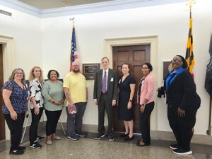 A group of eight people stand outside Steny Hoyer's office