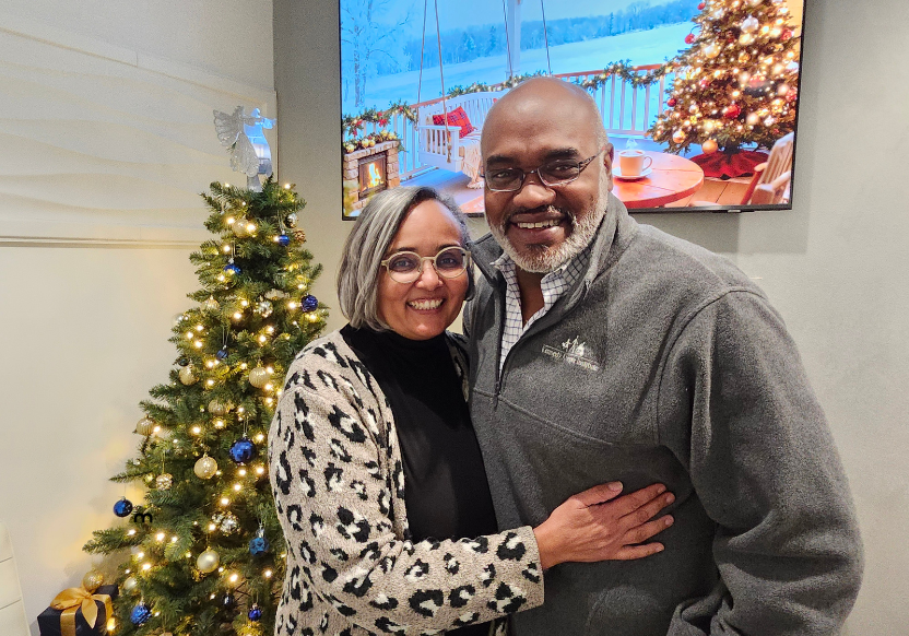Drs. Freeman and Thesiger standing side by side in front of holiday decorations.