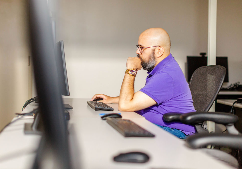 Cody, in a purple shirt, sits at a computer