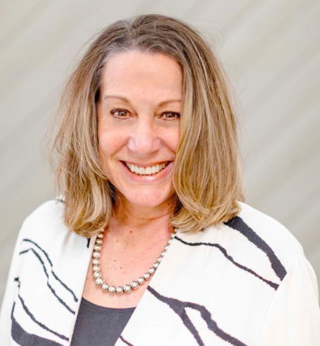 woman in white sweater with zebra stripes against a beige backdrop